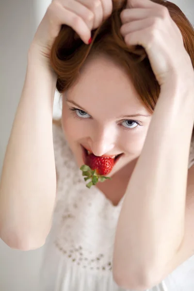 Unga vackra långhåriga kvinna äta mogen jordgubbe — Stockfoto