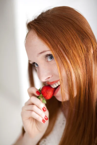 熟したイチゴを食べる若い美しい長い髪の女性 — ストック写真
