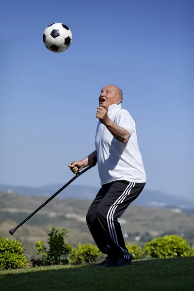 Soccerball を頭にステッキを引退したフットボール選手 — ストック写真