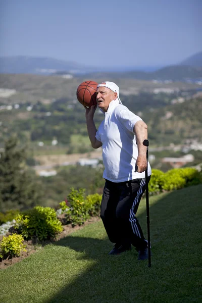 Jogador de basquete sênior com bengala jogando basquete — Fotografia de Stock