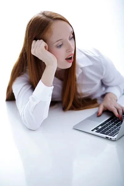 Heyecanlı bir iş kadını ile üzerine beyaz izole netbook bilgisayar — Stok fotoğraf