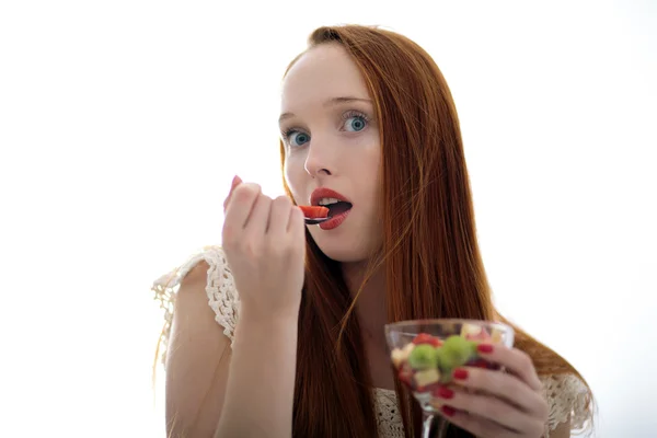 Jovem bela mulher de cabelos longos comendo frutas e olhando — Fotografia de Stock