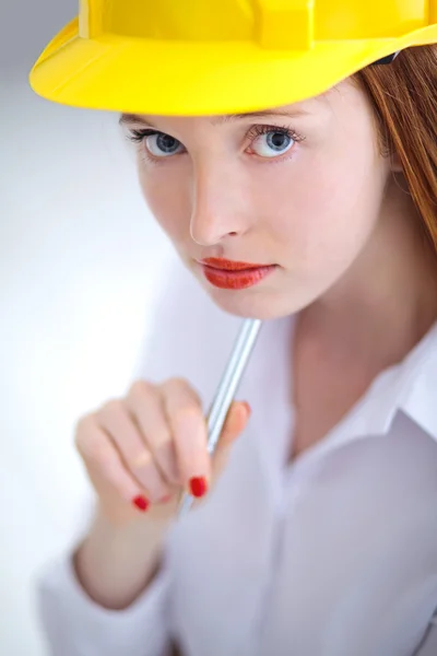Jonge mooie vrouw met gele helm houdt een pen — Stockfoto