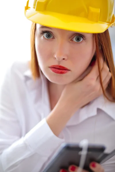 Jonge mooie vrouw met gele helm met behulp van een mobiele telefoon — Stockfoto