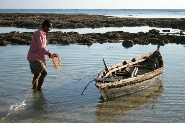 Рыбак и его лодка. Рыбак готовит лодку, прежде чем отправиться в море. Снимок сделан на острове Нил, Андаманские острова, январь 2008 . — стоковое фото