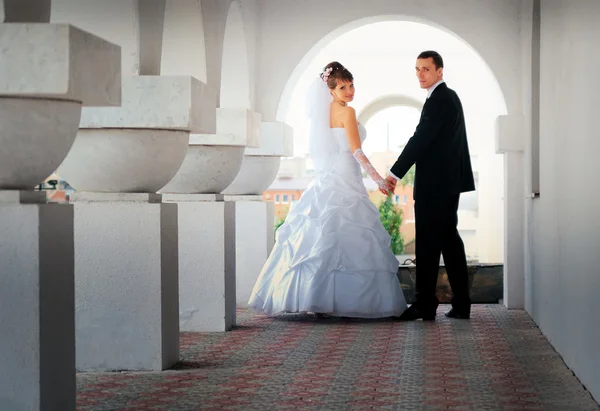 Sah das Brautpaar aus, in einem weißen Bogen stehend — Stockfoto