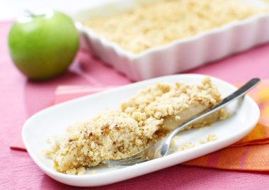 Delicious green apple crumble served on white plate clipart
