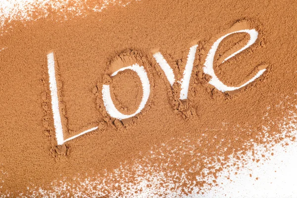 The word "love" written in Cocoa scattered Stock Picture
