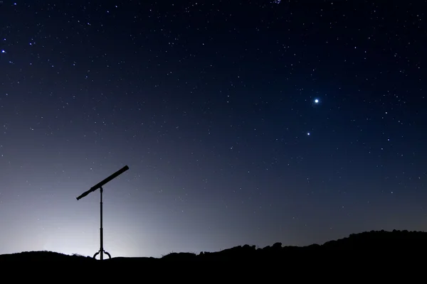 Nachtaufnahme mit der Silhouette eines Teleskops lizenzfreie Stockbilder