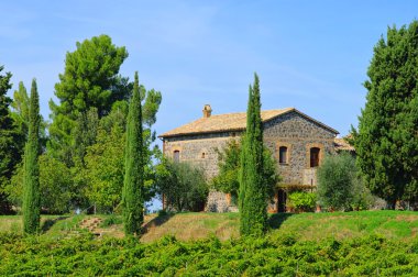 Tuscan çiftlik evi ve servi ağaçları.