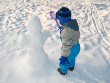 Little boy play on the snow clipart