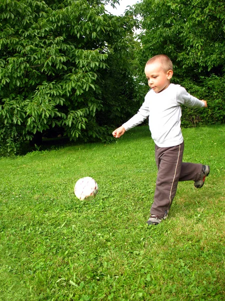 Маленький хлопчик грає у футбол — стокове фото