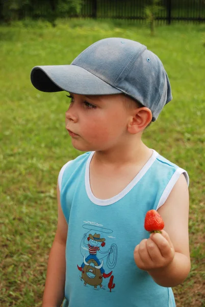 Маленький хлопчик їсть полуницю — стокове фото