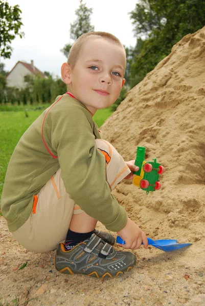 Liten pojke spela med sand — Stockfoto