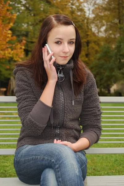 Mladá žena na mobilním telefonu — Stock fotografie