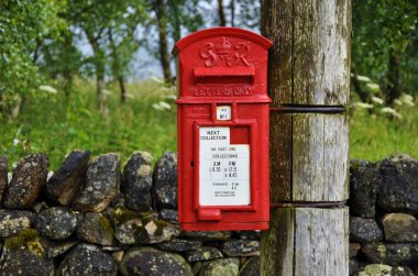 Traditional english postbox in countryside clipart