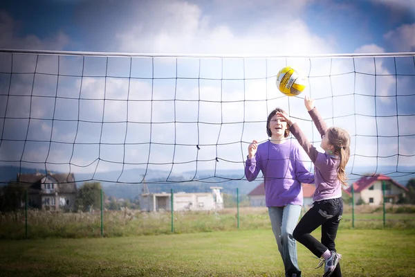 Две девушки играют в волейбол — стоковое фото