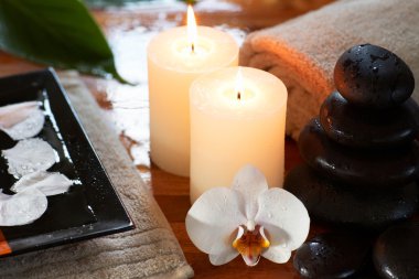 Relaxing spa with candles orchids towels and stones clipart