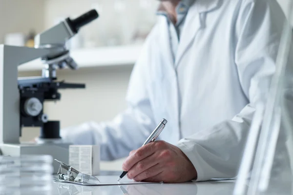 Scientist conducting research with microscope selective focus — Stock Photo, Image