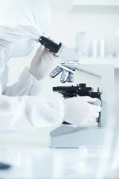 Вчений, що проводить дослідження в стерильній лабораторії під час перегляду мікроскопа вибіркового фокусу — стокове фото