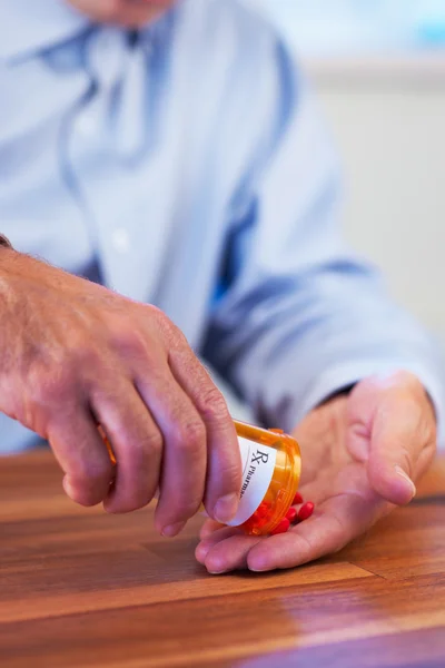 Nahaufnahme eines Patienten, der RX-Pillen in die Hand schüttet lizenzfreie Stockbilder