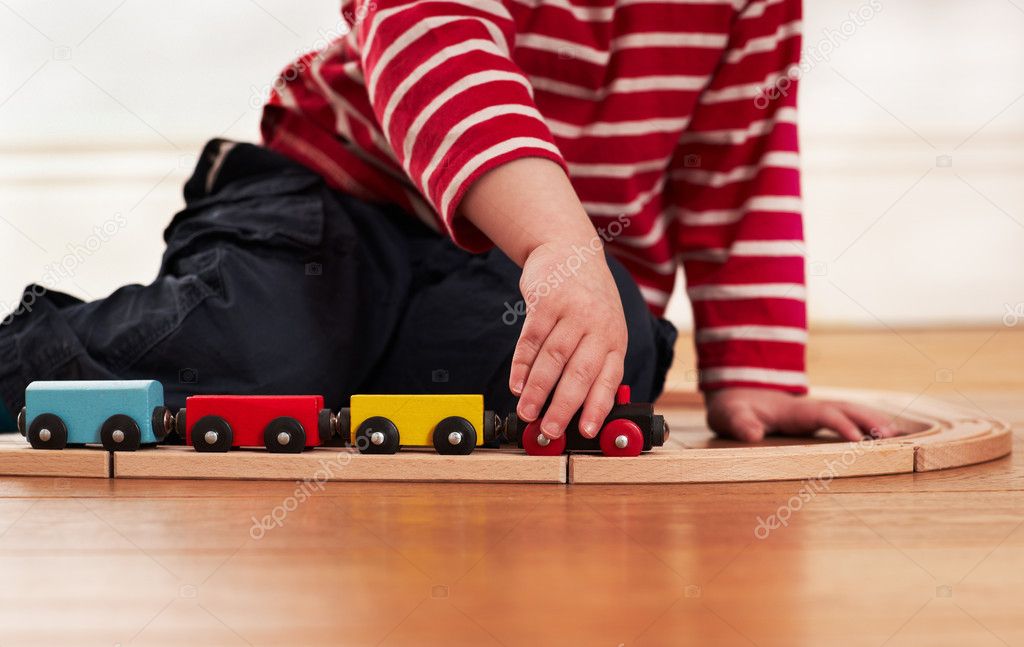 Child playing with toy wooden train
