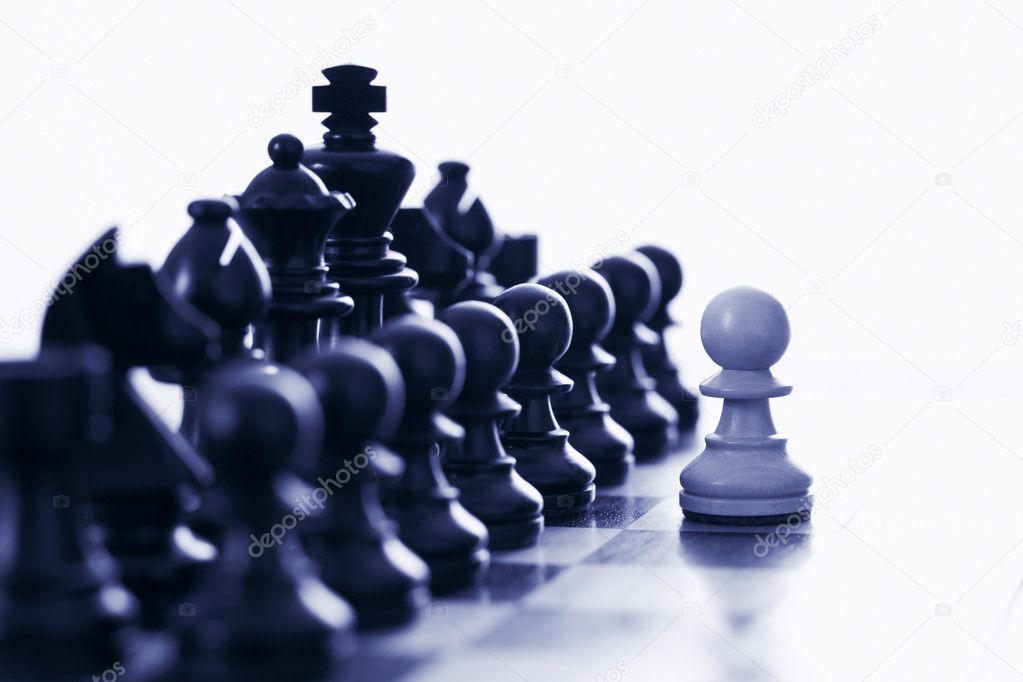 White pawn challenging black chess pieces