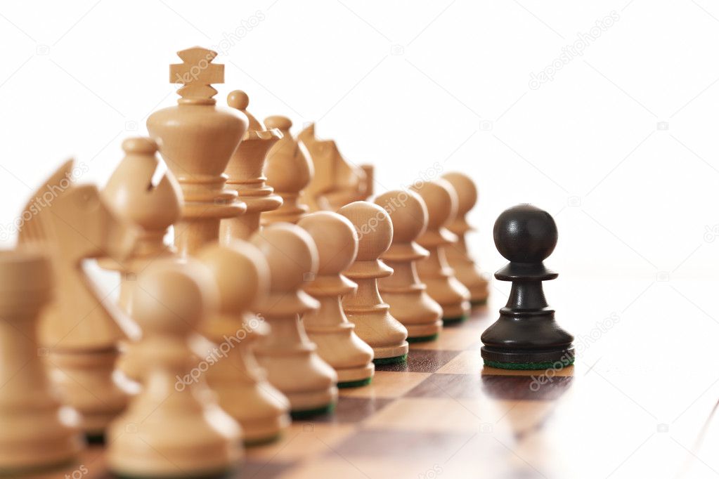 Black pawn challenging army of white chess pieces