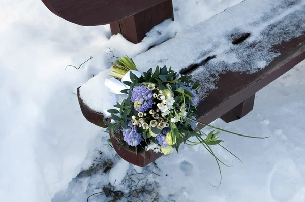 stock image A bouquet of flowers on a bench in the winter