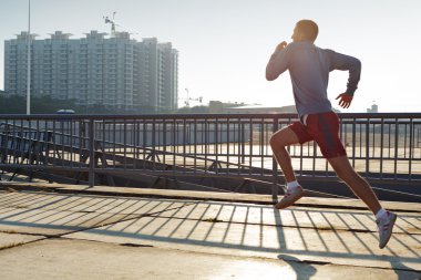 Young man warming-up at early morning clipart