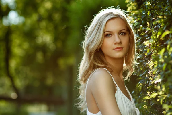 Vacker blond flicka med träd, vit klänning — Stockfoto
