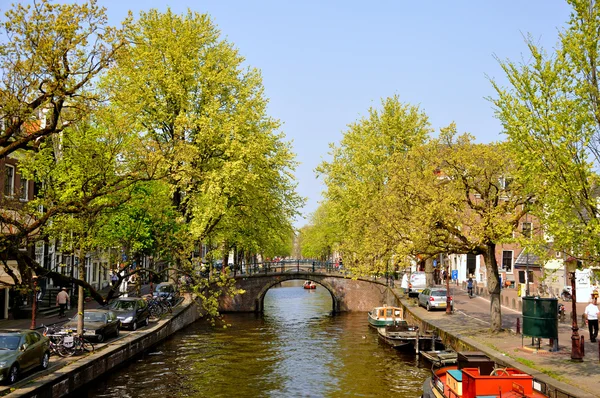 Piękna rzeka z łodzi i most w amsterdam, Holandia (netto — Zdjęcie stockowe