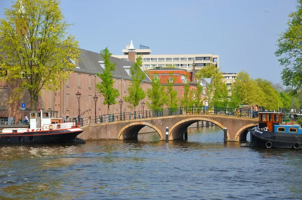 Bellissimo fiume con navi, Hermitage e ponte Amstel ad Amste — Foto Stock