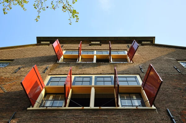 Vacker byggnad med open sun mörkar och fönster i amsterdam — Stockfoto