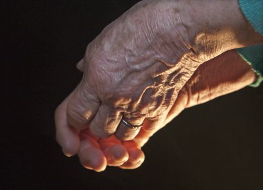 Hand of old woman in the dark and light clipart