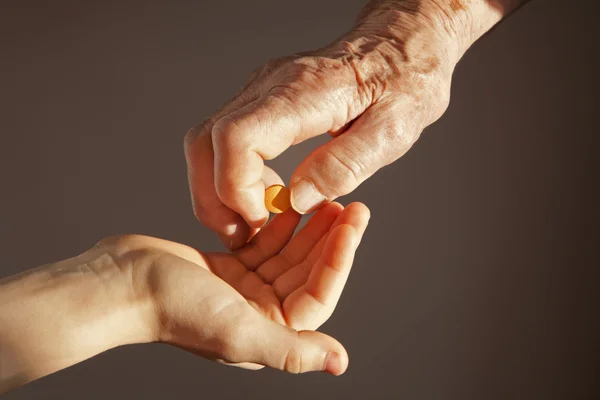 Рука бабушки и внука с таблеткой — стоковое фото