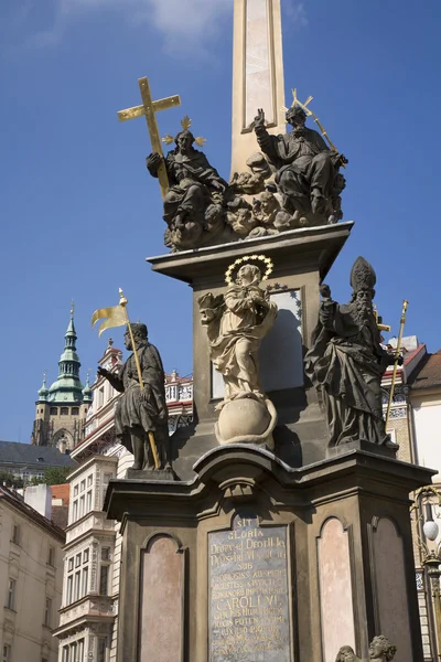 Praga - columna barroca de la Santísima Trinidad y torre de la catedral de San Vito —  Fotos de Stock