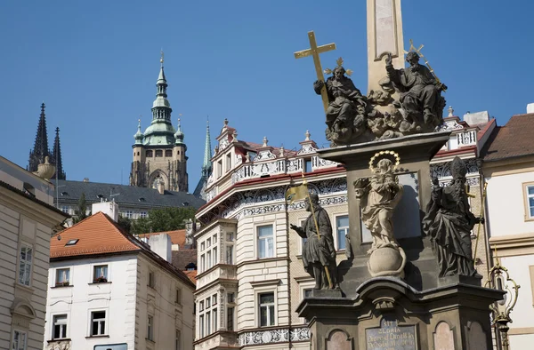 Praga - columna barroca de la Santísima Trinidad y torre de la catedral de San Vito — Foto de Stock
