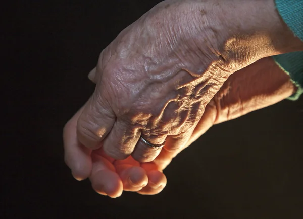 Hand av gammal kvinna i mörker och ljus — Stockfoto