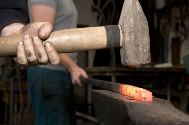 Hands of blacksmith at work clipart