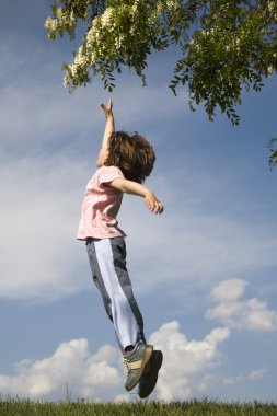 Jump of little girl and tree in the spring clipart