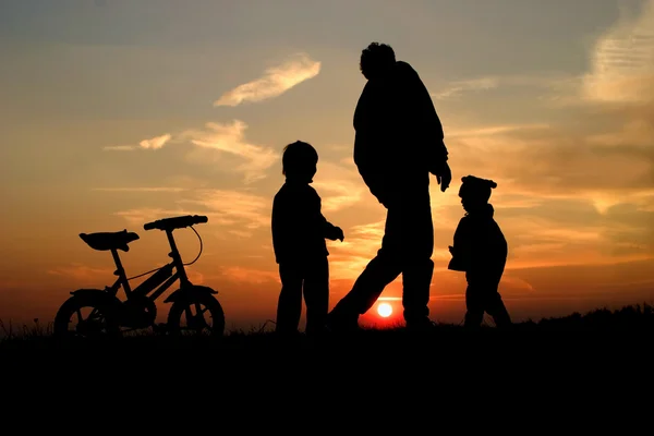 Silhoutte of mother and daughters by playing — Stock Photo, Image