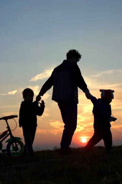 Mater and children - silhouette by sunset — Stock Photo, Image
