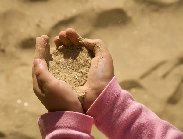 Hands of little girl and the sand — Stock Photo, Image