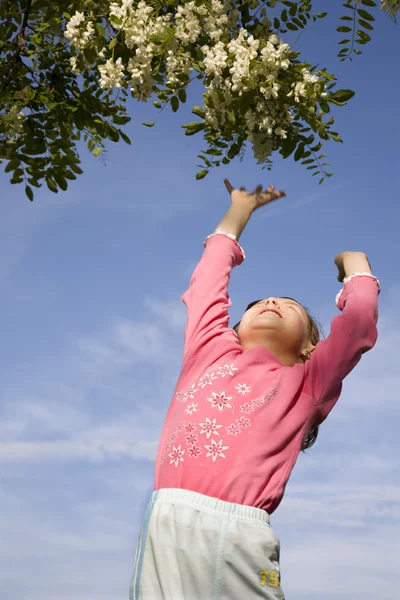 在春天跳的小女孩和树 — 图库照片