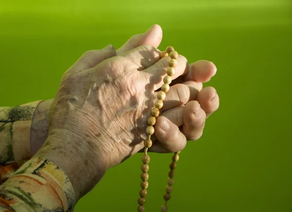 Hände der alten Frau durch Rosenkranzgebet — Stockfoto