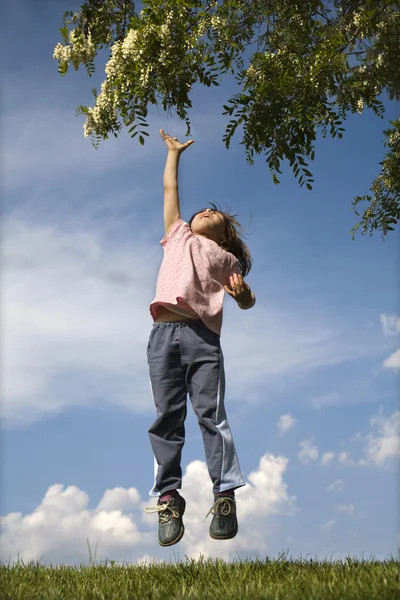 Jump of little girl and tree in the spring — Stock Photo, Image