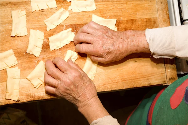 Hands of old woman by cooking — Stock Photo, Image