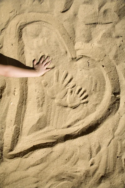 Kum ve el çocuğun kalbinde — Stok fotoğraf