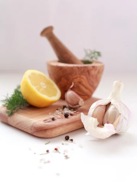 Holzmörser und Stößel mit Knoblauch, Zitrone, frischem Dill und Pfefferkörnern — Stockfoto